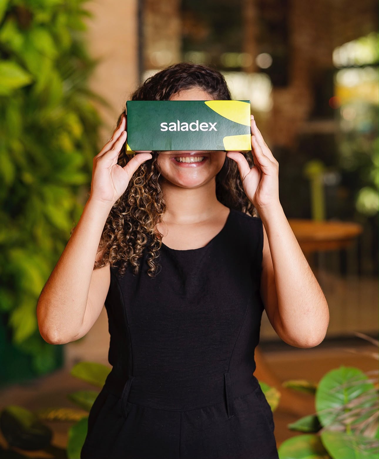 Colaboradora Saladex segurando uma embalagem verde da marca